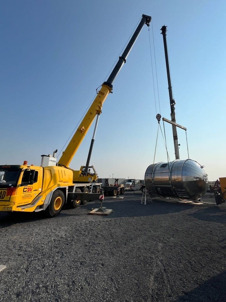 Crane operator running a precision lift on an industrial jobsite