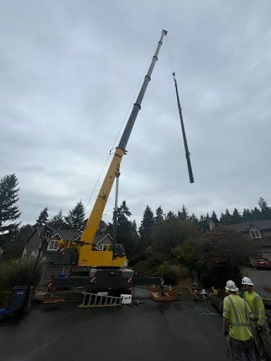 NCCCO certified operator running an all-terrain crane on a pole set with the crew standing clear